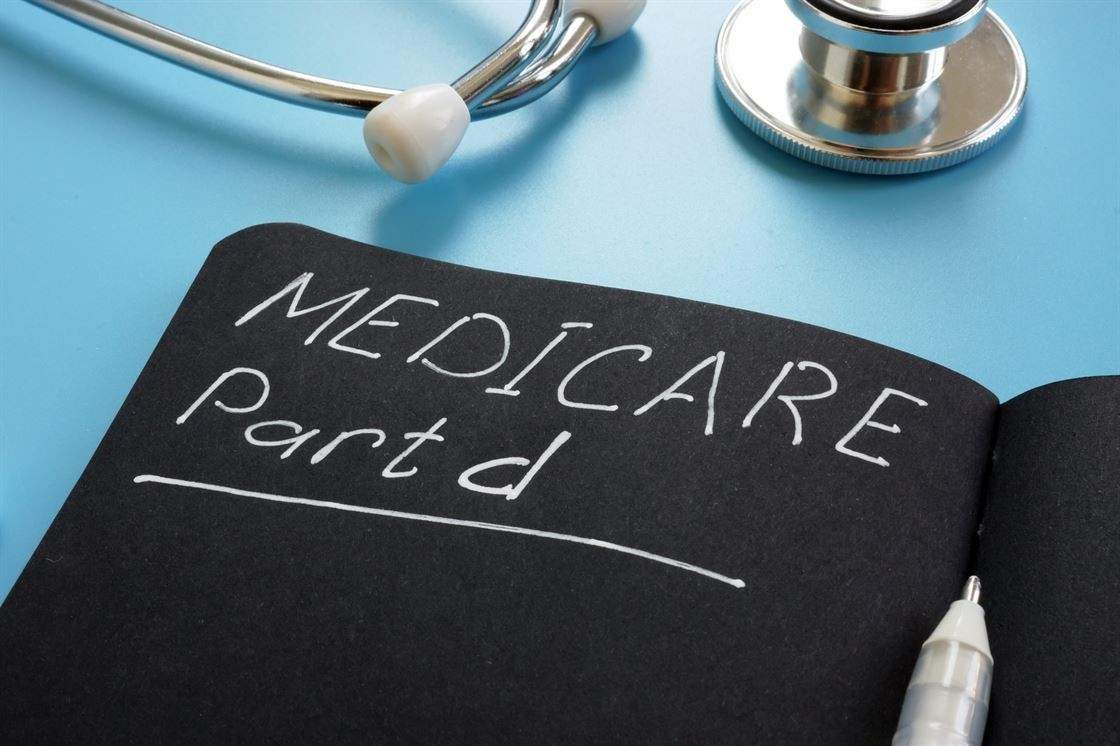 Medicare Part D sign on a black page with a stethoscope lying beside it.